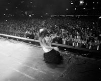 a black and white photo of a woman on stage